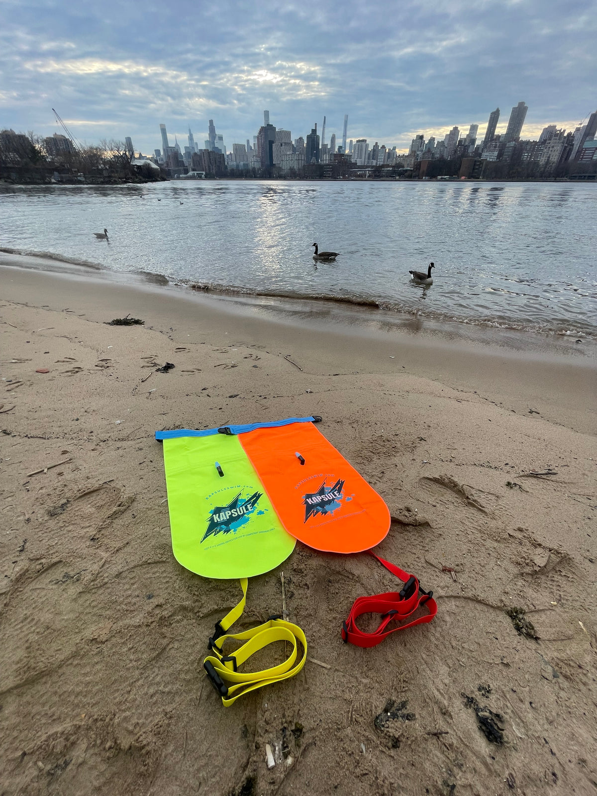 KAPSULE Bolt swim buoy neon yellow high-visibility open water safety float on beach